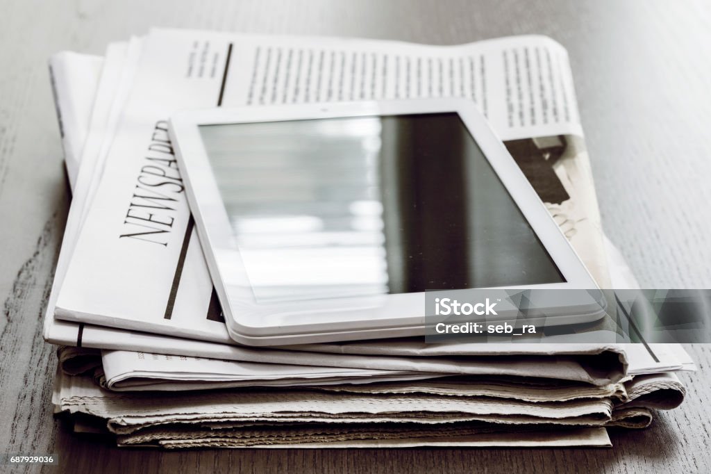 Newspaper and digital tablet on wooden table Newspaper Stock Photo