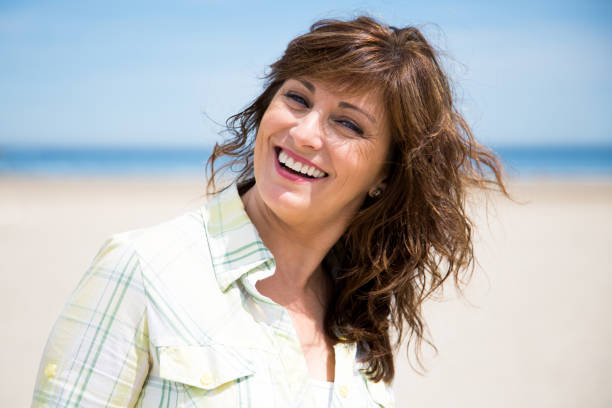 istock Pretty middle aged woman on the beach 687931956