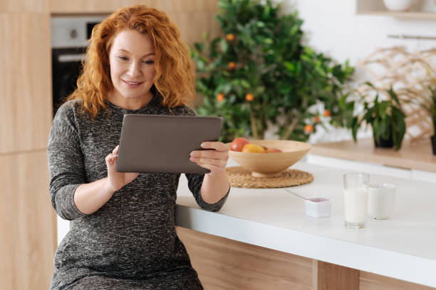 istock Beautiful pregnant woman using tablet during breakfast 687932086