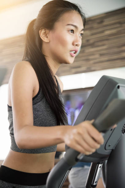 istock Asian woman exercising on Elliptical trainer machine at the gym. 687932184