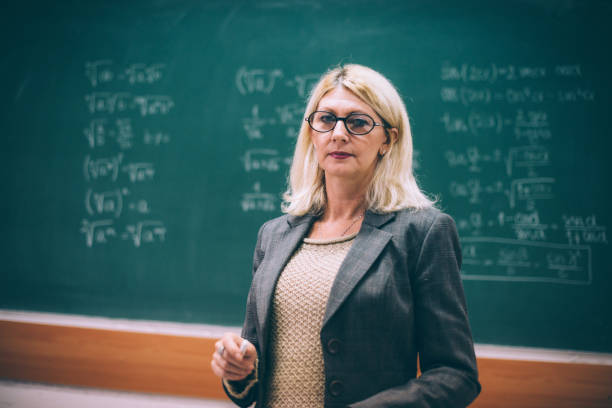 istock Senior math professor in lecture hall near the blackboard with formulas 687936816