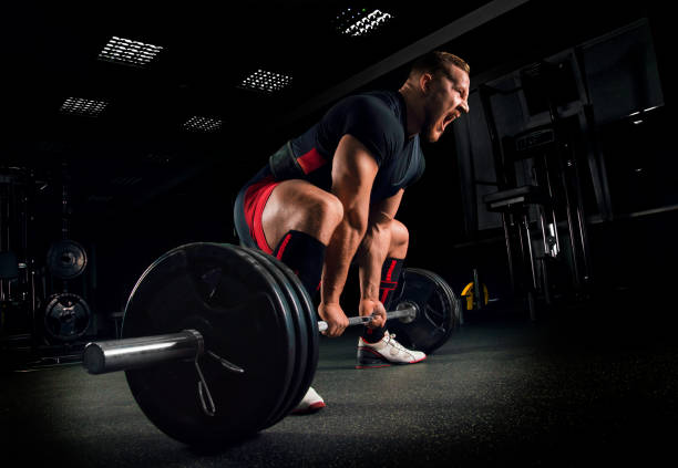 istock Athlete screams to motivate himself to perform an exercise called deadlift 687939516