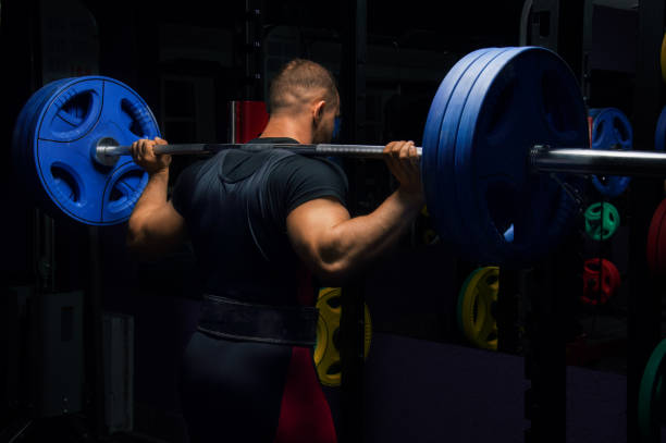 istock Professional athlete stands with a barbell on his shoulders 687939584