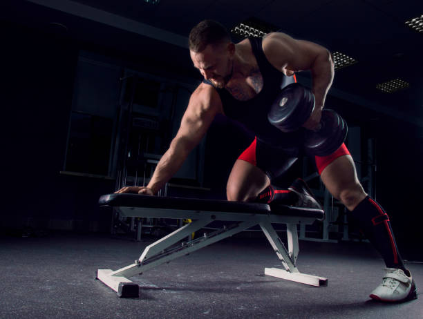 istock Professional athlete pulls the dumbbells to the stomach 687939606