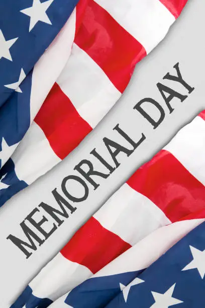 Closeup of two fabric flags of United States with text of memorial day