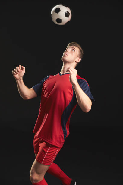 istock Professional Soccer Player Heading Ball In Studio 687946408