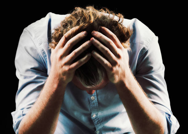 istock Despairing mature man, his head in his hands, looks down 687950786