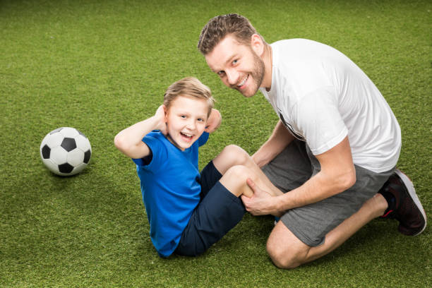 istock side view of father and son training together on grass 687954806