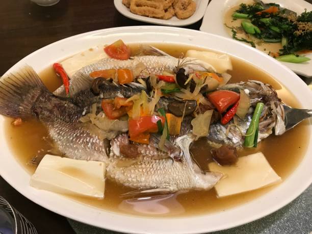 istock fresh steamed whole fish covered with herbs onions 687955092
