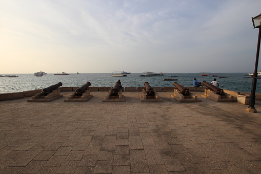 Historical Cannons at the Seafront of Forodhani Gardens in Stone Town during sunset. Stone Town is the historic part of Zanzibar City, which is the main city of Zanzibar island. Zanzibar is a semi-autonomous part of Tanzania in East Africa.