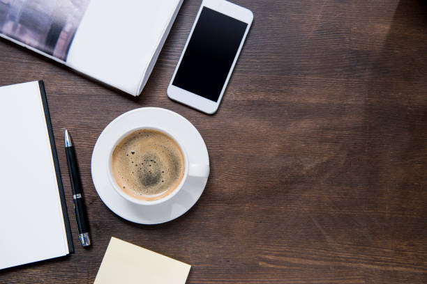 istock coffee cup, smartphone with blank screen,on wooden table 687958198