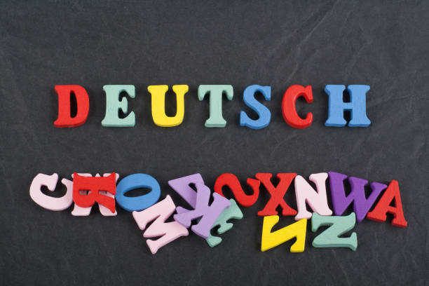 istock DEUTSCH word on black board background composed from colorful abc alphabet block wooden letters, copy space for ad text. Learning english concept 687958558