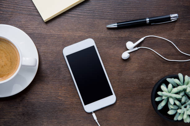 istock coffee cup, smartphone and earphones on wooden table 687959900