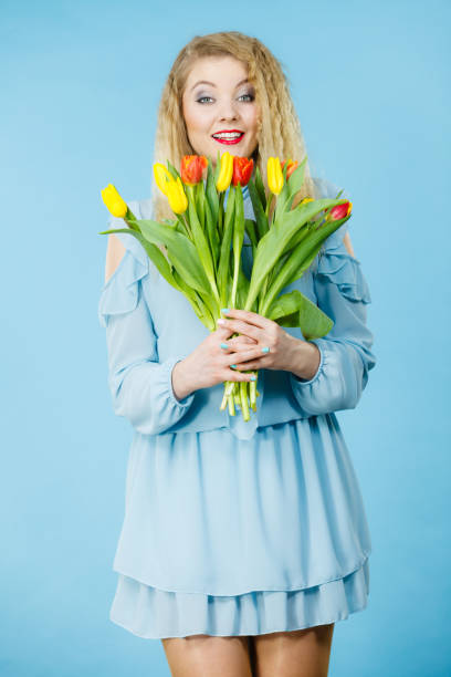 istock Pretty woman with red yellow tulips bunch 687964290