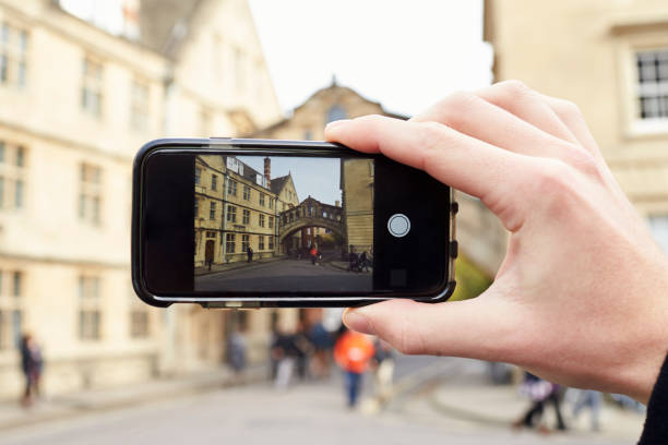 oxford/ uk- october 26 2016:tourist photographing bridge of sighs in oxford on mobile phone - hertford college imagens e fotografias de stock