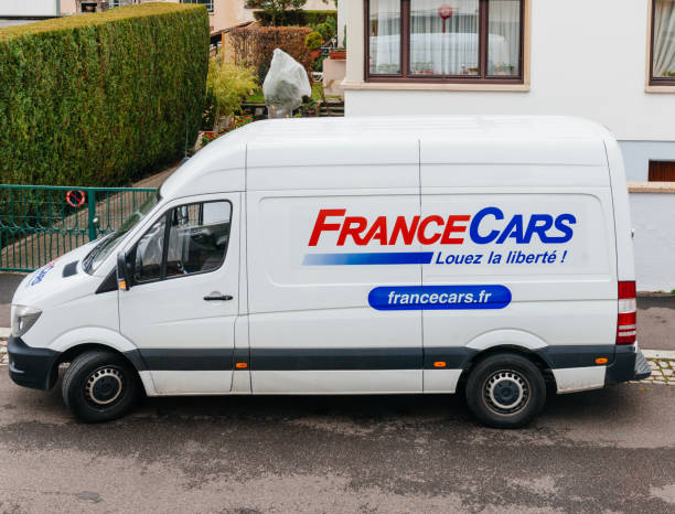 フランス車フランスの都市で白いレンタルバン - car delivering white mini van ストックフォトと画像