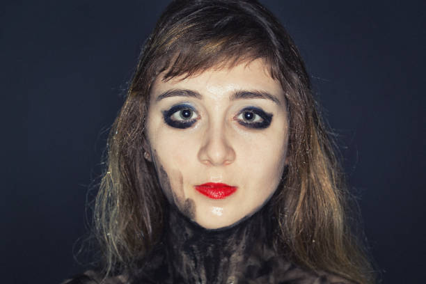 Young girl's face with bright makeup on dark background