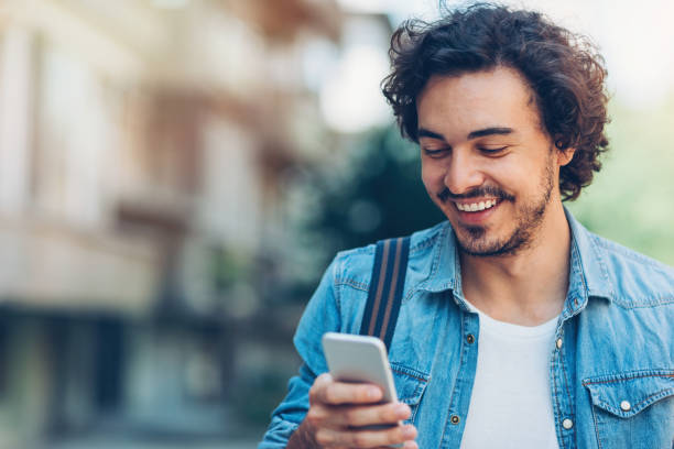 uśmiechnięty mężczyzna ze smartfonem - adult brown hair caucasian close up zdjęcia i obrazy z banku zdjęć