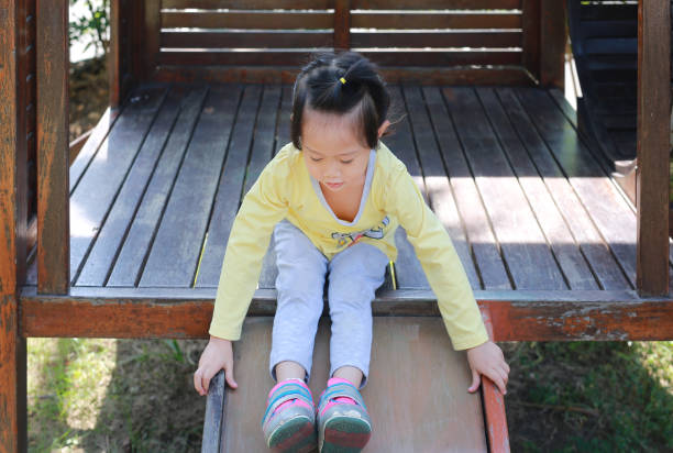istock Little child girl playing on slider. 687965574