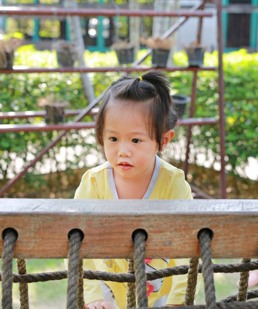 istock Little child girl playing on climbing net. 687967856