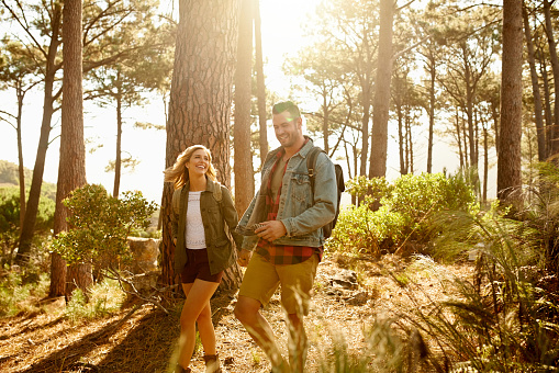 Shot of a happy young couple going for a romantic walk in the woods