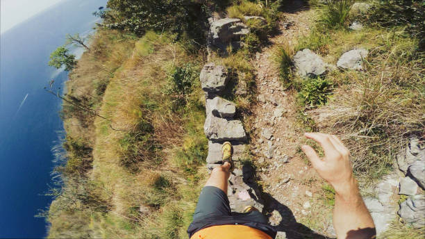 Man trail running on a single track on high cliff