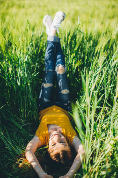 istock Smiling girl lying in wheat 687969004