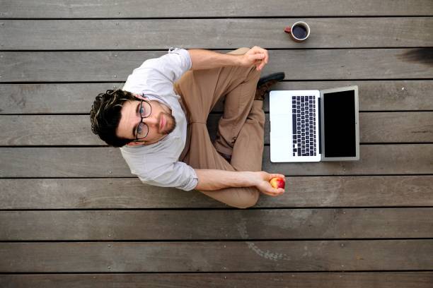 istock Young adult man using laptop during coffee break 687969034