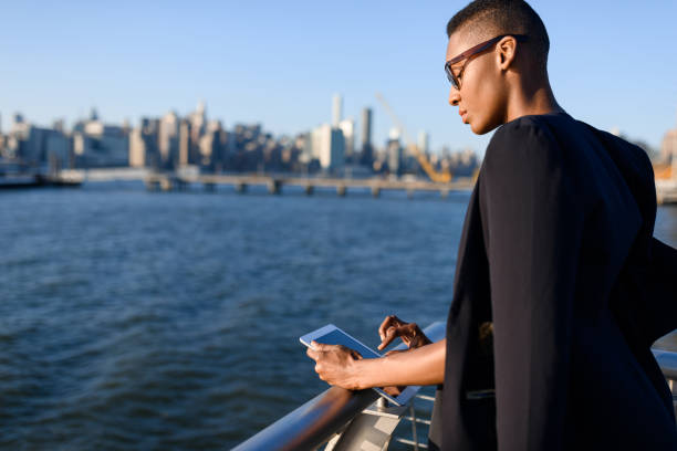 Young african fashionable businesswoman working outdoor, New York, Manhattan view, skyline stock photo