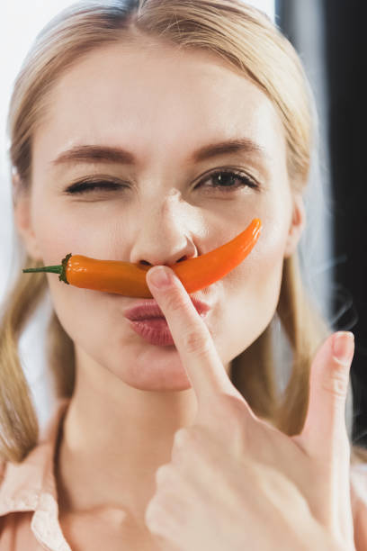 istock girl with chili pepper as mustache 687987384