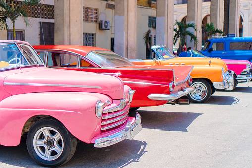 Havana, Сuba - April 21, 2018: Vintage American cars in front of Gran Teatro de La Habana waiting for passengers, Havana Vieja, Cuba.