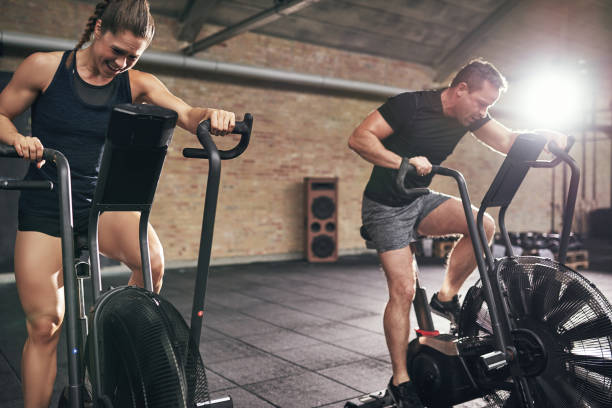 istock Man and woman riding on cycling machines 687998548