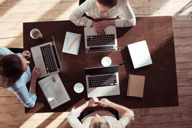 istock businesswomen working at table on new business project 688002520