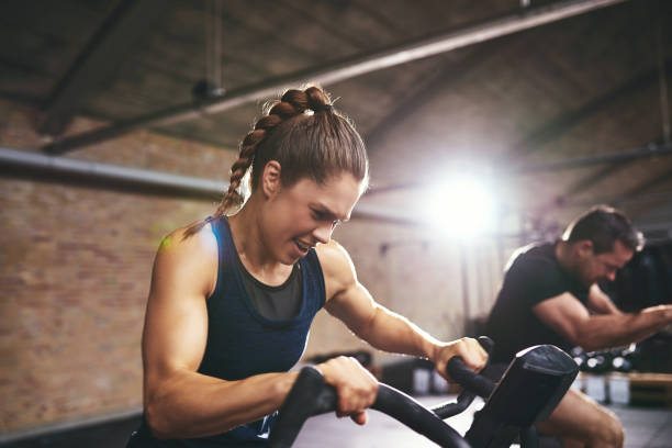 istock People working hard on exercycle in gym 688008386
