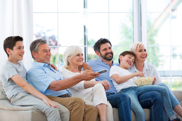 istock Family watching tv on sofa 688008772