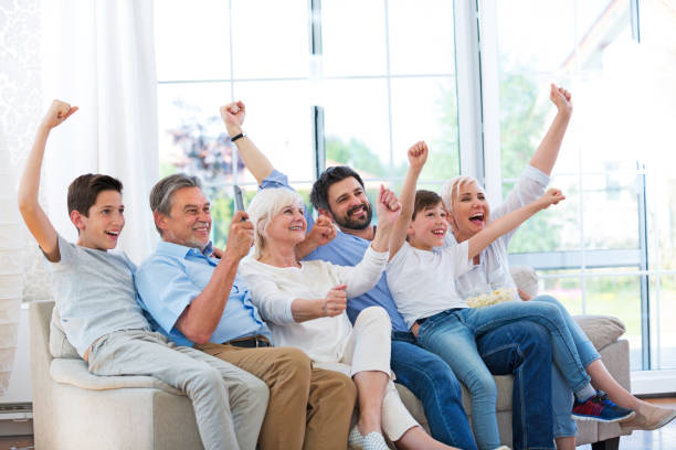 istock Excited family watching television on sofa 688008852