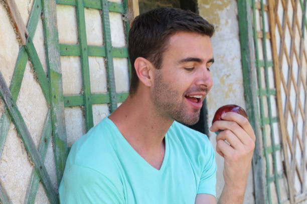 istock Healthy man joyfully eating an apple 688018834