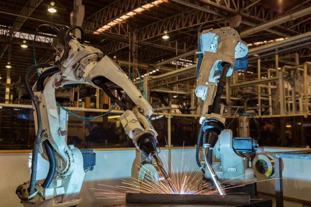 istock Team robots are welding in car factory 688018964