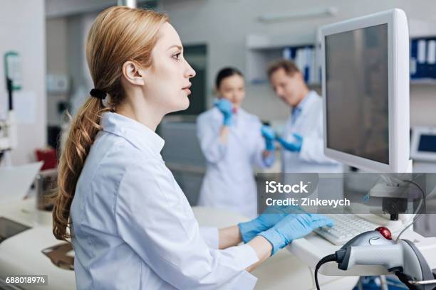コンピューターにテキストを入力する魅力的な女性労働者 - ゲノム学のストックフォトや画像を多数ご用意 - ゲノム学, 技術者, ヘルスケアと医療
