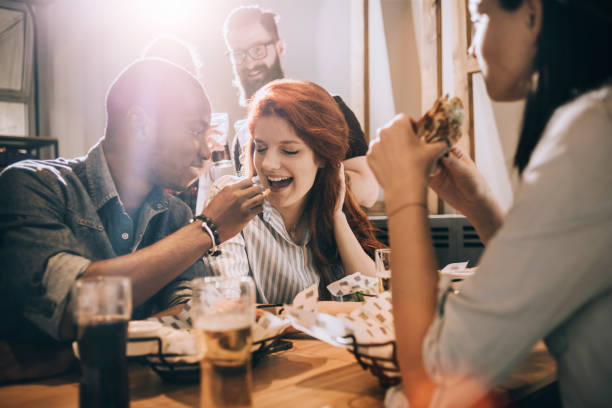 istock group of playful friends eating and having fun 688019302