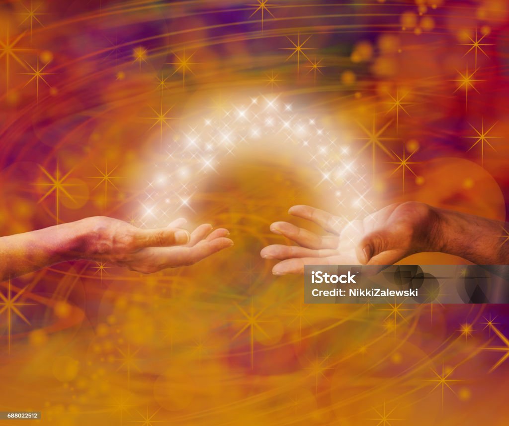 Soulmate Interaction Man and woman both with one hand each palm up with an arc of white light and sparkles joining them on an amber coloured energy formation background Reiki Stock Photo