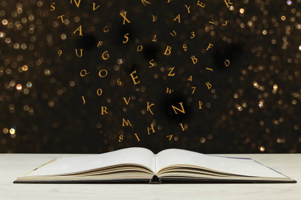 istock Flying letters from the opened book on wooden table 688025998