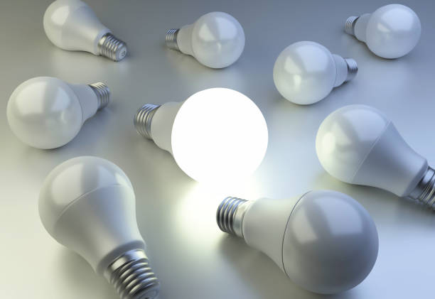 istock LED Light bulbs are scattered on the surface and one bulb shining. The concept of individuality and leadership. 688028818