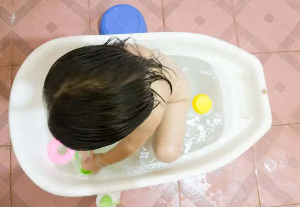 Photo of Girl playing water in a tub