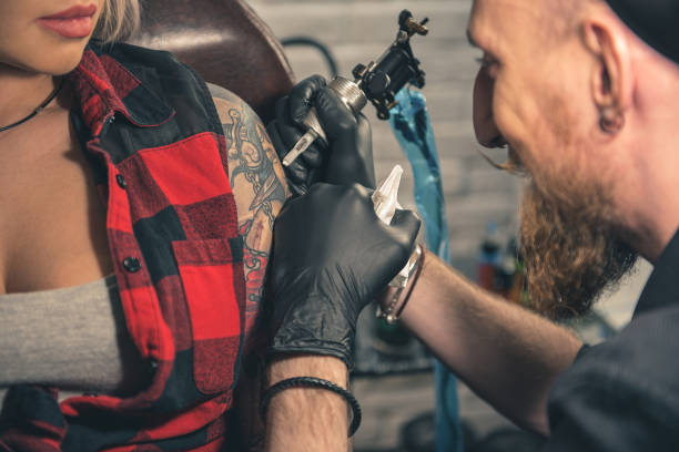 istock Happy man creating tattoo on hand in room 688037448