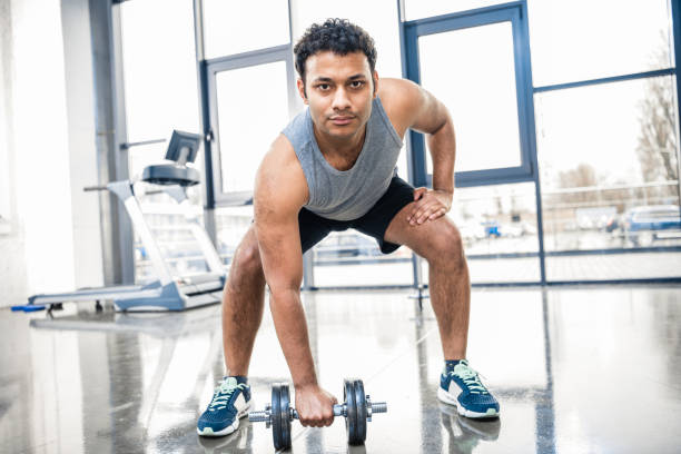 istock Handsome young man workout with dumbbell at gym 688037648