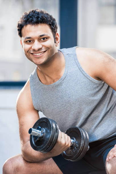 istock Handsome young man workout with dumbbell at gym 688037778
