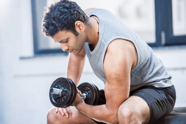 istock Handsome young man workout with dumbbell at gym 688038232