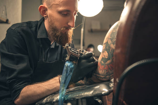 istock Serene male doing tattoo in salon 688040300