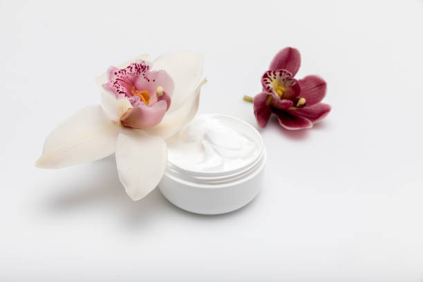 istock Close-up view of organic cream in container with orchids isolated on white 688047062